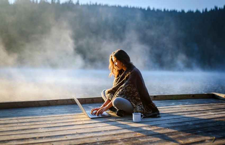 Woman with laptop on dock